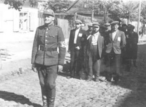 Боец «литовской самообороны» конвоирует группу арестованных евреев. Лето 1941 г.