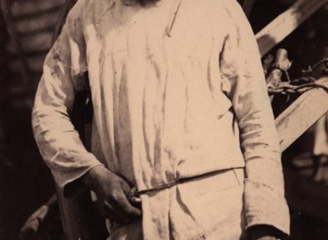 Поволжский крестьянин на фоне избы.